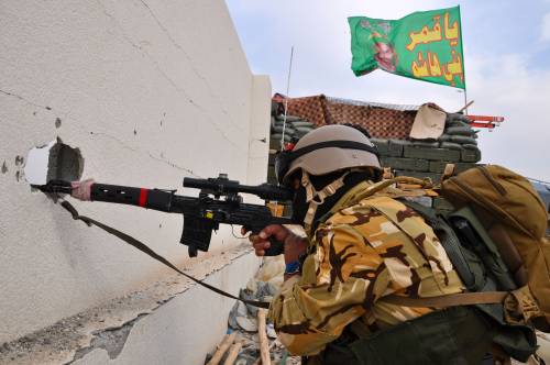 Cecchino dei corpi speciali irahceni a Tikrit. Sullo sfondo al bandiera con l'imam Hussein venerato dagli sciiti