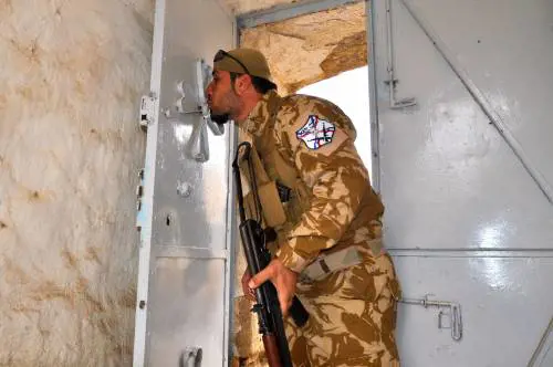 Volontario cristiano bacia la croce all'ingresso della chiesa di San Giorgio a Bakufa villaggio abbandonato vicino a Mosul