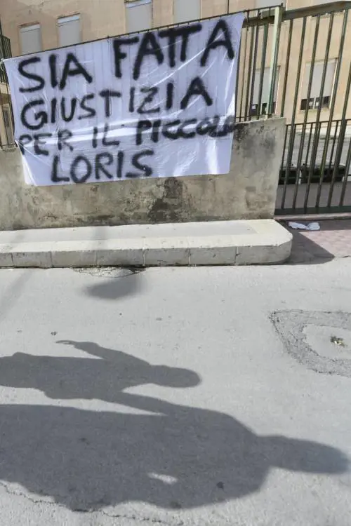 Lo striscione apparso davanti all'elementare che frequentava Loris