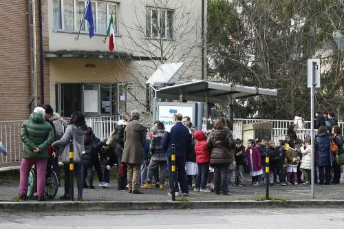 Insegnanti e alunni all'esterno della scuola elementare Pascolì, evacuata a Siena