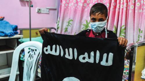 Un bambino malato di cancro con una bandiera dello Stato islamico