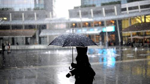 La prima neve scende su piazza Gae Aulenti a Milano