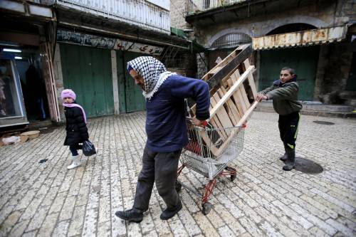 Un gruppo di palestinese recupera legname da ardere a Hebron