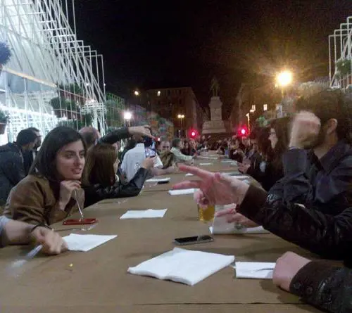Maccheroni e birra seduti a una tavolata davanti al Castello 