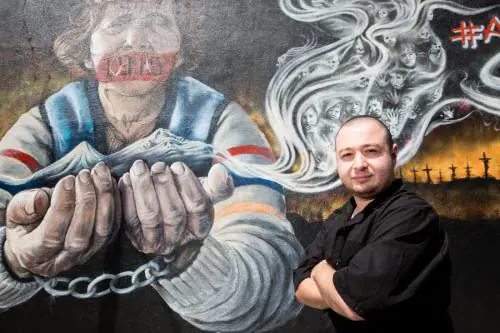 Harut giovane pizzaiolo di origini armene di fronte alla sua pizzeria