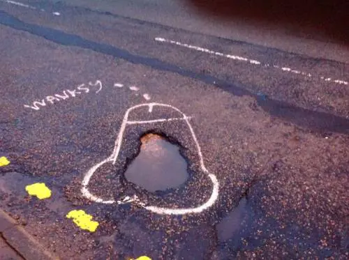 Buche per strada e disegni a luci rosse