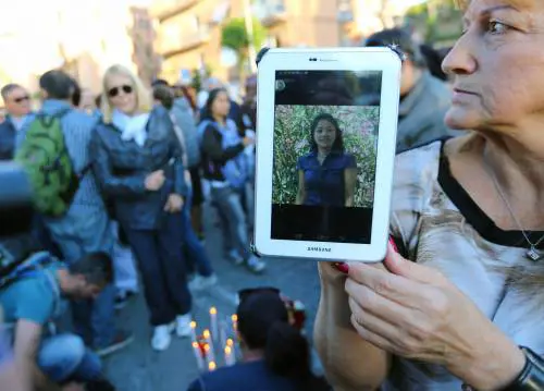 Una donna mostra un'immagine di Corazon Perez Abordo