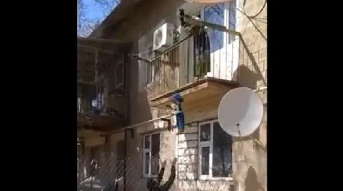 Lancia il bimbo al padre dal balcone