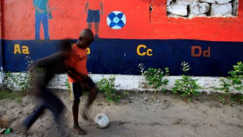 Bambini giocano a calcio per le vie di Monrovia