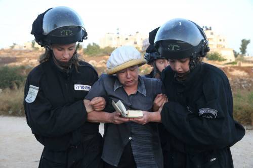 Poliziotte israeliane portano via una anziana colona a Beit El