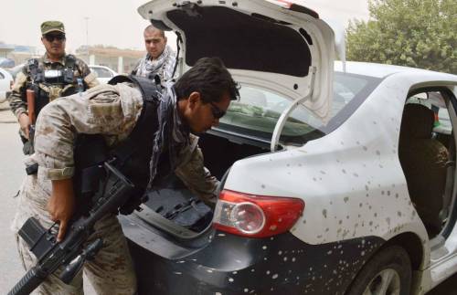 Un soldato afgano perquisisce un veicolo sulla strada per Kunduz