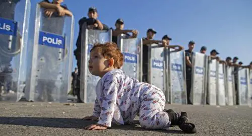 La baby profuga gattona davanti al muro di agenti: una foto creata ad hoc?