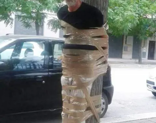 Disabile legato ad un albero con lo scotch. La foto finisce su Facebook