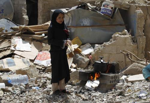 A Sanaa una ragazzina cucina su un fuoco improvvisato tra le macerie