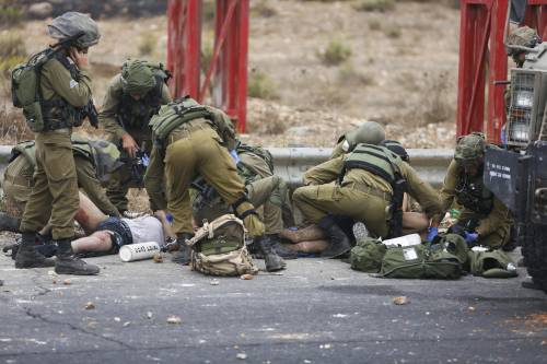 Militari israeliani curano persone rimaste ferite durante gli scontri vicino a Ramallah