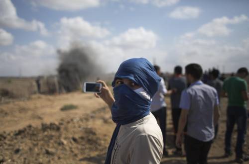 Un giovane palestinese riprende gli scontri al confine di Gaza