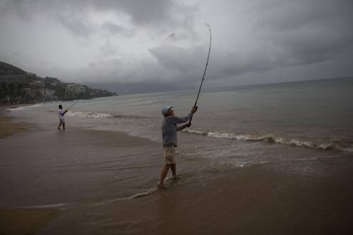 Pescatori sulla spiaggia mentre Patricia si avvicina alle coste messicane