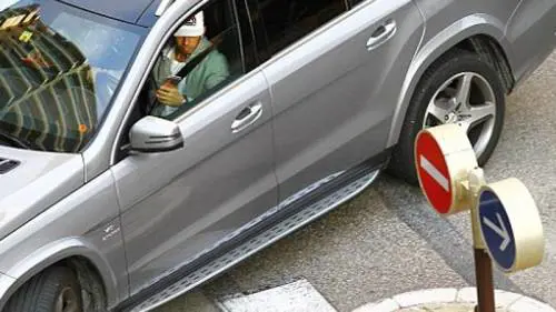 Lewis Hamilton al volante col cellulare in mano