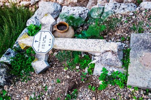 Una delle croci divelte al cimitero cattolico