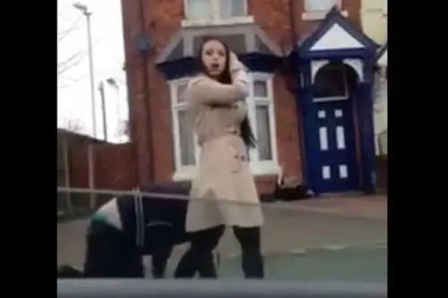 Una dominatrice tiene al guinzaglio un uomo per strada