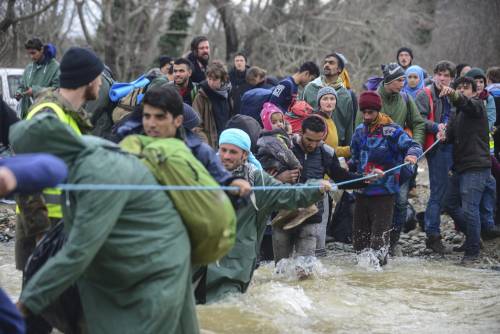 I migranti guadano il fiume tra Grecia e Macedonia