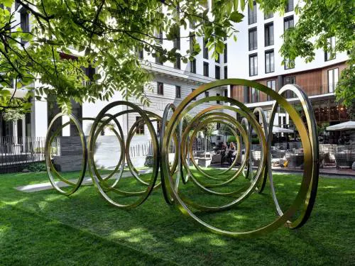 18 anelli in acciaio brillano nel giardino del Bugari Hotel 