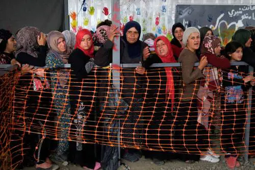 Donne in coda per i vestiti al campo tra Grecia e Macedonia