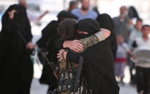 Una combattente curda delle Ypj abbraccia una donna con il niqab a Manbij