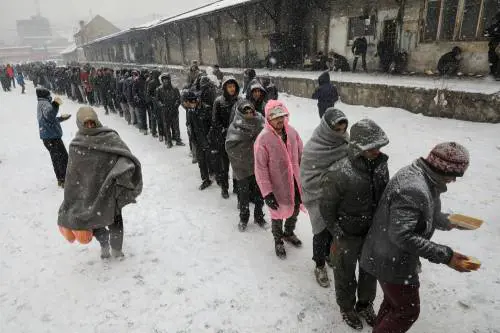 Migranti in fila nella neve a Belgrado