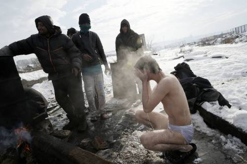 Immigrati bloccati a Belgrado costretti a lavarsi tra la neve