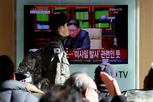 Un miltare sudcoreano passa davanti a una tv che trasmette le parole di Kim