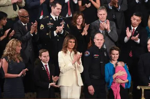 La first lady Melania incanta in bianco. Ma arriva sola e a braccetto di un militare