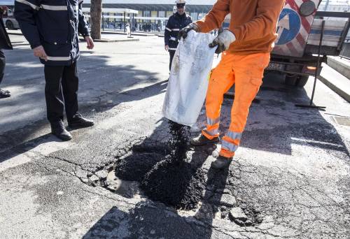 Gli interventi dei vigili urbani per riempire le buche sulle strade della Capitale