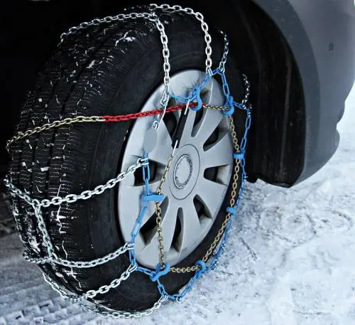 Investita dalla sua auto mentre il marito monta le catene da neve