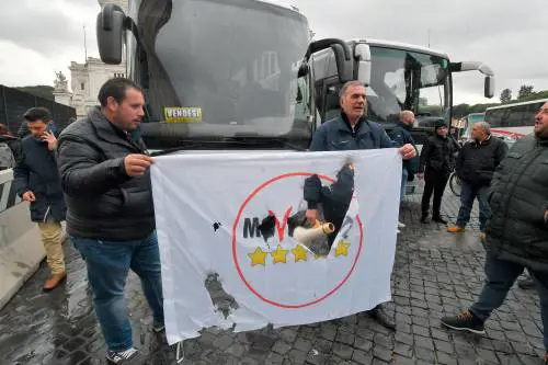 Il centro di Roma ancora bloccato. I bus turistici occupano piazza Venezia, bruciata bandiera M5S