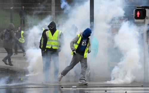 Parigi, gilet gialli contro la polizia: barricate e transenne in fiamme
