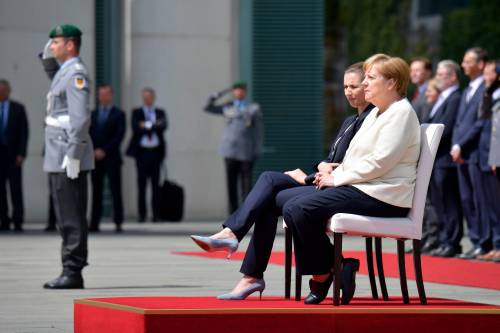 Angela Merkel rimane seduta durante gli inni nazionali