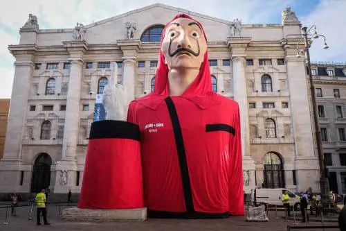 Il cast de "La Casa di Carta" davanti all'installazione in piazza Affari