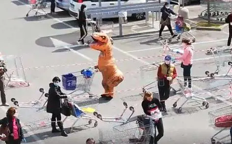 Travestito da dinosauro in coda al supermercato