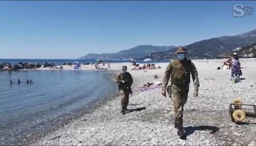 Militari con mitra e anfibi in spiaggia a Ventimiglia: "Controllano le distanze di sicurezza e i migranti la fanno da padroni"