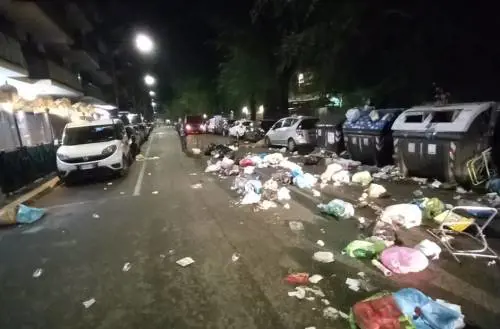Incappucciati gettano i sacchi dell'immondizia per strada