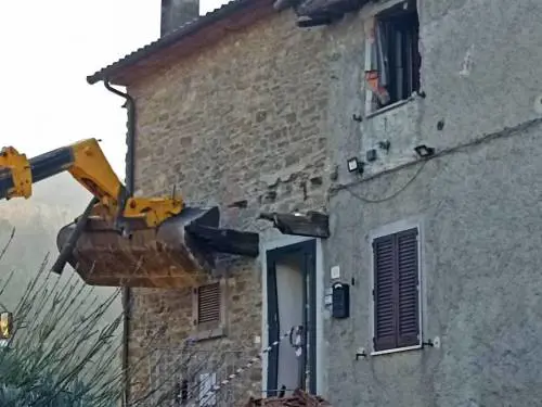 La casa colpita dalla ruspa