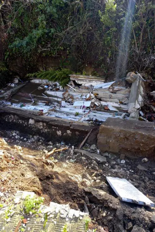 L'orrore al cimitero: bare e urne finiscono nel torrente