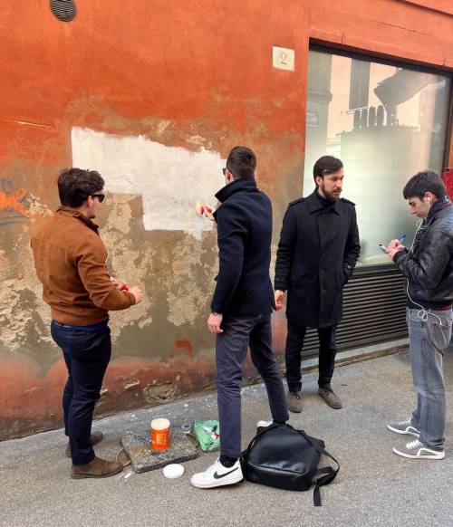 I giovani di Gioventù Nazionale di Ferrara e l'assessore Balboni impegnati a riverniciare il muro vandalizzato