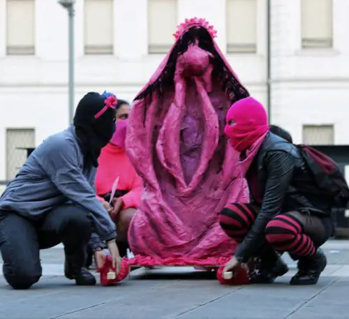 Due attiviste accanto al fantoccio a forma di vulva che ha innescato la polemica