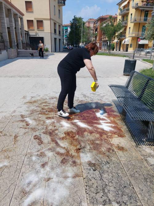 Un'esponente del centrodestra impegnata a ripulire la piazza dalle chiazze di sangue