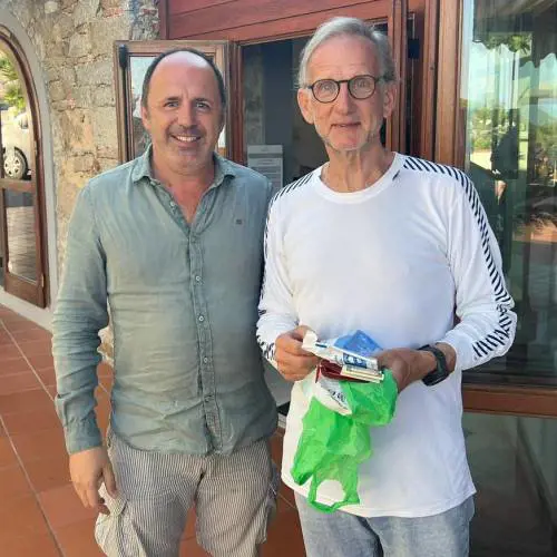 Il consigliere leghista Marco Landi (a sx) riconsegna la busta al turista