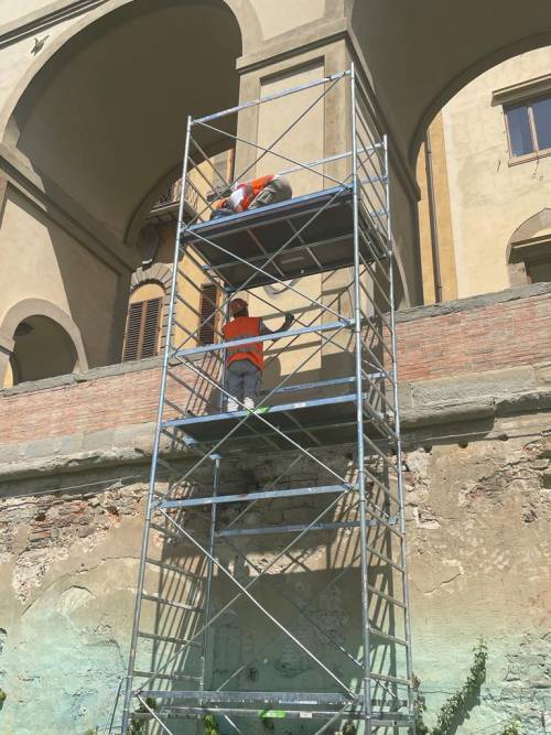 Gli operai al lavoro per ripulire i pilastri del Corridoio Vasariano, dopo l'atto vandalico