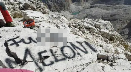 la frase offensiva composta sulla roccia con la bomboletta spray