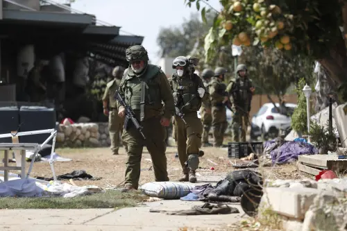 I soldati israeliani radunano e portano via i cadaveri dal kibbutz